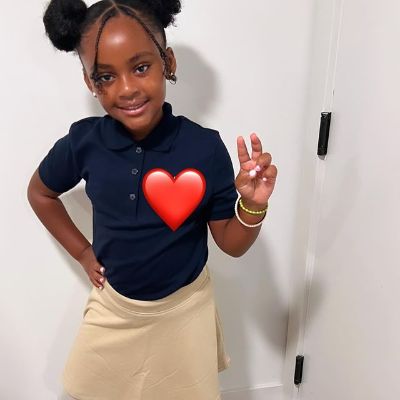 She is posing with a peace sign as mom has edited the picture with red heart emoji on her.